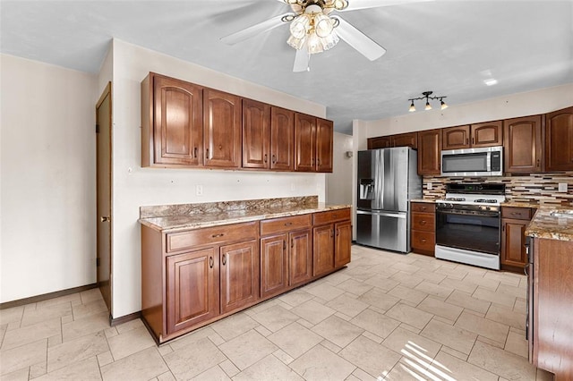 226 Ridgeview Dr, Columbia, IL 62236 - kitchen with appliances with stainless steel finishes, a ceiling fan, light stone countertops, decorative backsplash, and baseboards