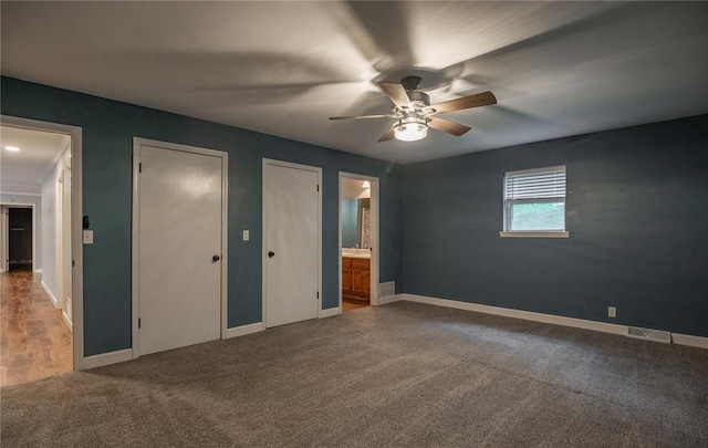 2137 Inman Rd, Poplar Bluff, MO 63901 - unfurnished bedroom featuring multiple closets, carpet, baseboards, ensuite bathroom, and ceiling fan