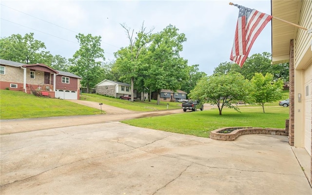 2137 Inman Rd, Poplar Bluff, MO 63901 - view of grassy yard with driveway, an attached garage, and a residential view