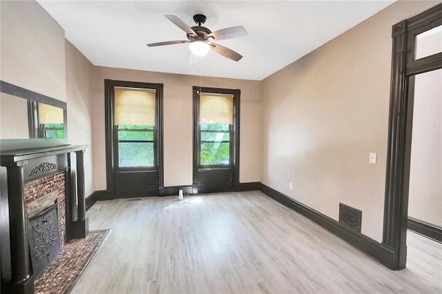 4541 Oakland Ave, Saint Louis, MO 63115 - unfurnished living room featuring wood finished floors, baseboards, a fireplace with flush hearth, and a ceiling fan