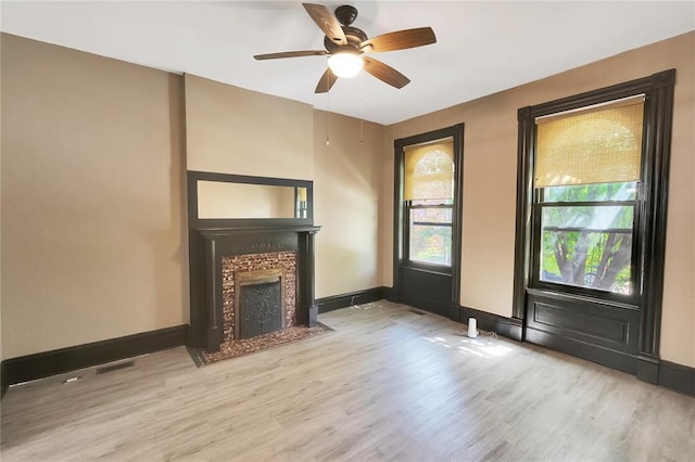 4541 Oakland Ave, Saint Louis, MO 63115 - unfurnished living room with wood finished floors, baseboards, a tile fireplace, and ceiling fan
