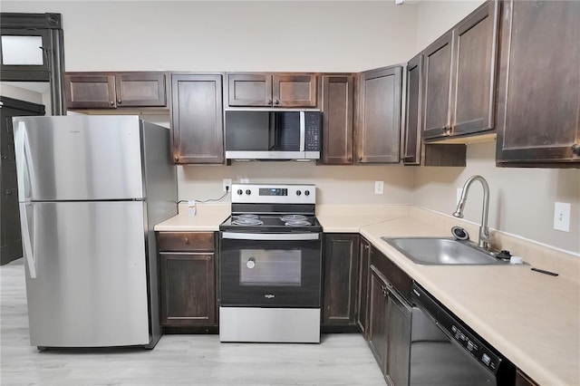 4541 Oakland Ave, Saint Louis, MO 63115 - kitchen featuring stainless steel appliances, a sink, and dark brown cabinets