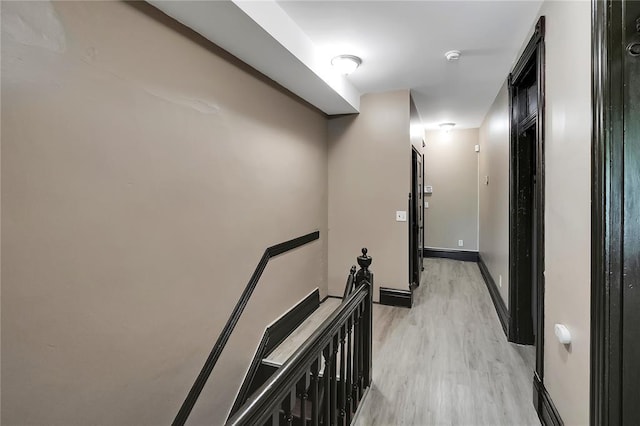 4541 Oakland Ave, Saint Louis, MO 63115 - hallway with light wood finished floors, baseboards, and an upstairs landing