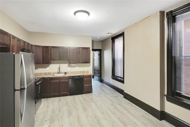 4541 Oakland Ave, Saint Louis, MO 63115 - kitchen featuring black appliances, light countertops, light wood-style floors, dark brown cabinets, and baseboards