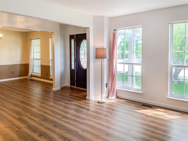 entrance foyer with wood finished floors, baseboards, and a chandelier