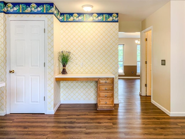 corridor featuring wallpapered walls, baseboards, and dark wood-type flooring