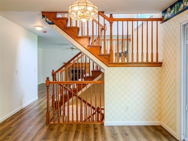 stairs with baseboards, wood finished floors, and a chandelier
