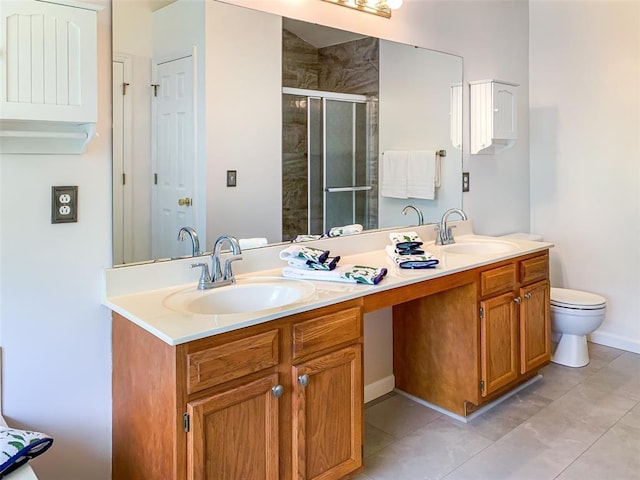 bathroom featuring a shower stall, double vanity, tile patterned floors, toilet, and baseboards