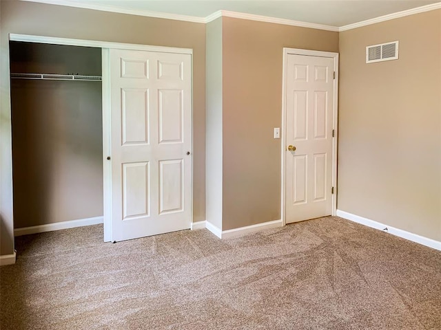 unfurnished bedroom with carpet flooring, crown molding, baseboards, and a closet