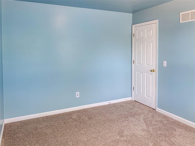 carpeted spare room featuring baseboards