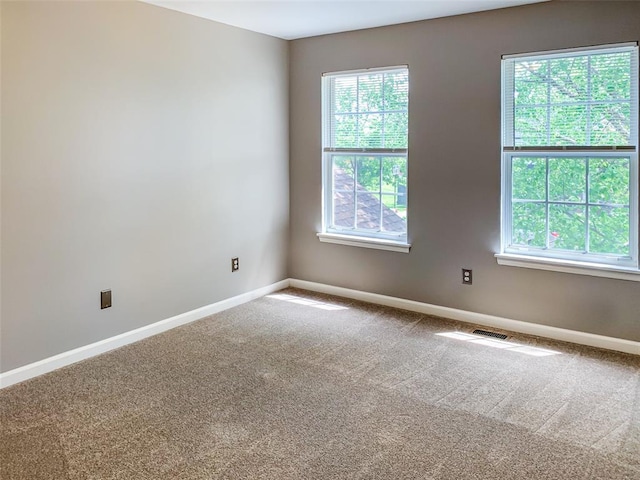 empty room featuring carpet flooring and baseboards