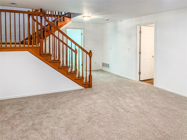 unfurnished living room featuring carpet flooring, baseboards, and stairway