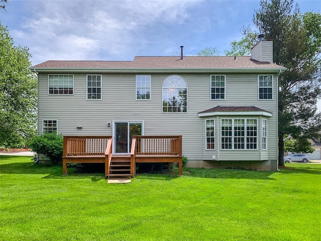 rear view of house featuring a chimney, a yard, and a wooden deck