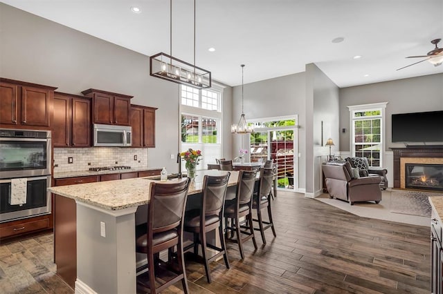 40 Burnside Ct, Frontier Township, MO 63303 - kitchen featuring appliances with stainless steel finishes, open floor plan, a chandelier, tasteful backsplash, and dark wood-style flooring