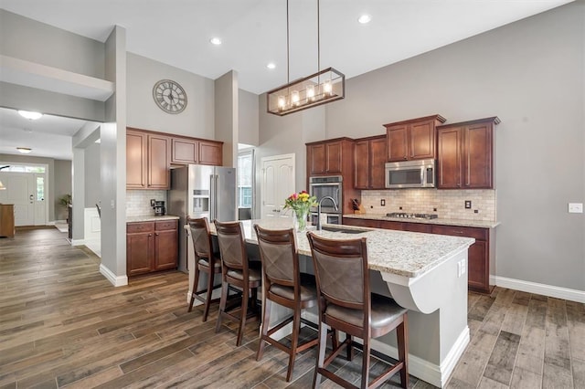 40 Burnside Ct, Frontier Township, MO 63303 - kitchen featuring appliances with stainless steel finishes, a towering ceiling, dark wood finished floors, baseboards, and an island with sink