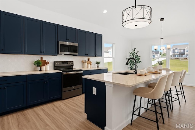 203 Homestretch Ln, Wentzville, MO 63385 - kitchen with appliances with stainless steel finishes, blue cabinets, light wood-style flooring, decorative backsplash, and recessed lighting