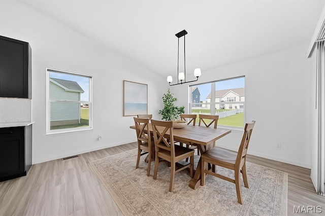 203 Homestretch Ln, Wentzville, MO 63385 - dining space with light wood-type flooring, lofted ceiling, and a chandelier