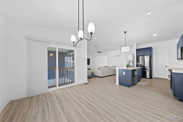 203 Homestretch Ln, Wentzville, MO 63385 - kitchen featuring stainless steel appliances, open floor plan, blue cabinetry, light wood-type flooring, and recessed lighting