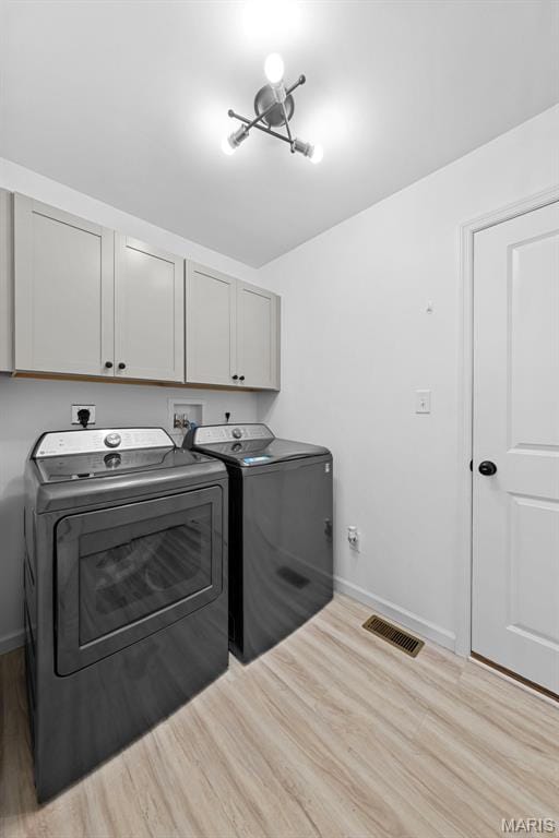 203 Homestretch Ln, Wentzville, MO 63385 - laundry area featuring cabinet space, washer and clothes dryer, and light wood-style flooring
