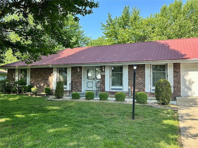 ranch-style home featuring a garage, a front yard, and brick siding