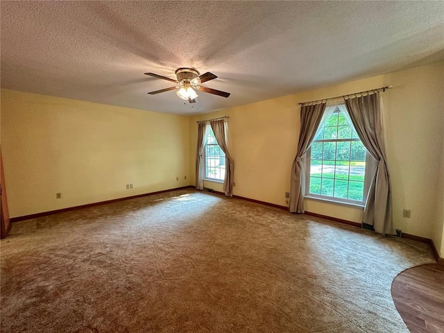 unfurnished room featuring healthy amount of natural light, carpet, a textured ceiling, ceiling fan, and baseboards