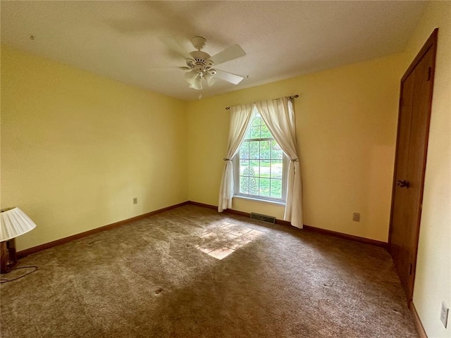 carpeted spare room with ceiling fan and baseboards