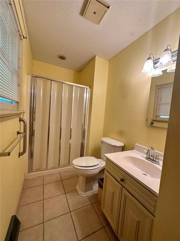 full bath with a textured ceiling, a shower stall, toilet, tile patterned floors, and vanity