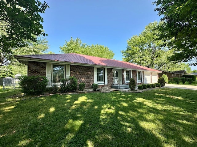 single story home with brick siding, an attached garage, metal roof, and concrete driveway