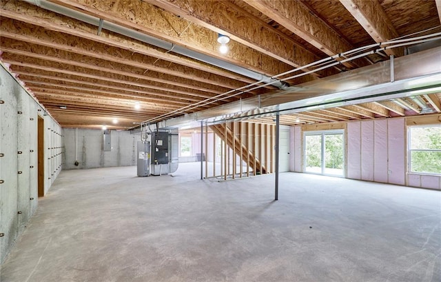 below grade area featuring electric water heater, heating unit, and electric panel