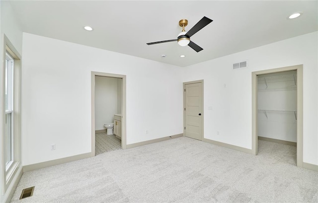 unfurnished bedroom with light colored carpet, recessed lighting, a spacious closet, baseboards, and a closet