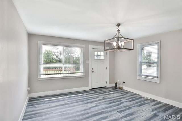 5333 Helen Ave, Jennings, MO 63136 - unfurnished dining area featuring a chandelier, wood finished floors, and baseboards