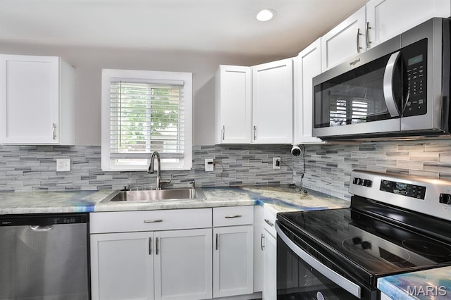 5333 Helen Ave, Jennings, MO 63136 - kitchen with appliances with stainless steel finishes, a sink, white cabinets, decorative backsplash, and recessed lighting