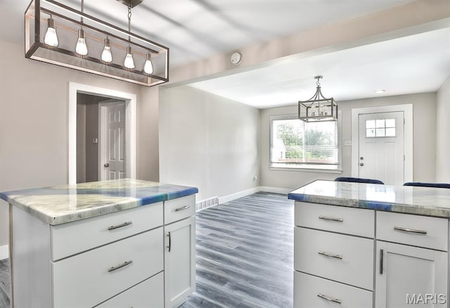 5333 Helen Ave, Jennings, MO 63136 - kitchen with a chandelier, baseboards, white cabinets, and light stone counters
