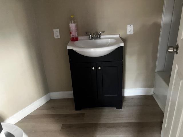 423 W Mckinley Ave, Bernie, MO 63822 - bathroom with wood finished floors, vanity, and baseboards
