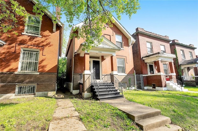 view of front of home featuring brick siding, a front lawn, and a residential view