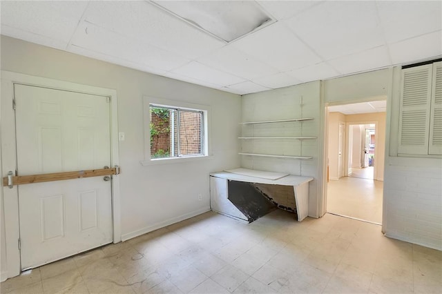 entrance foyer with a paneled ceiling, light flooring, and baseboards