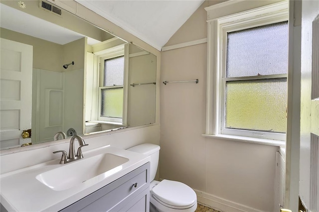 bathroom featuring toilet, lofted ceiling, vanity, and a shower