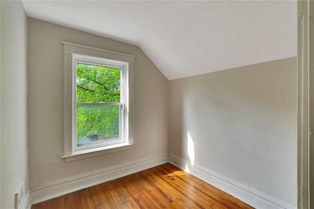 bonus room featuring vaulted ceiling, wood-type flooring, and baseboards