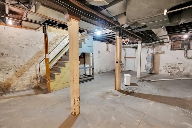 unfinished basement with gas water heater and stairway