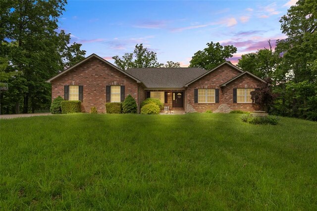 ranch-style house with brick siding and a lawn