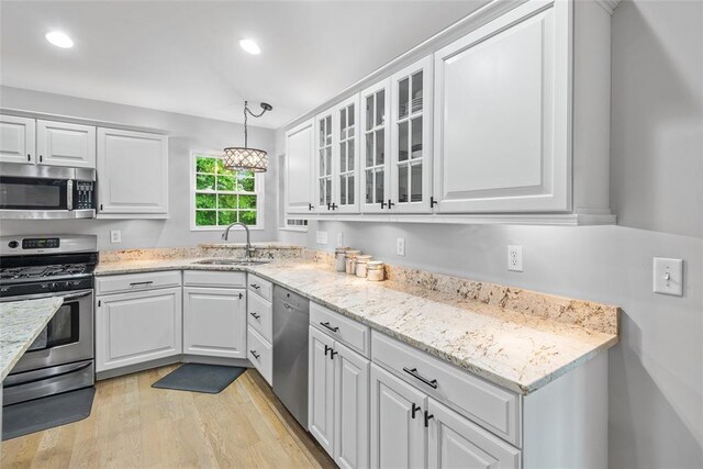 kitchen featuring appliances with stainless steel finishes, a sink, white cabinetry, and recessed lighting