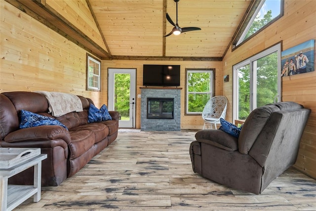 living area with lofted ceiling, wood ceiling, wood walls, wood finished floors, and ceiling fan