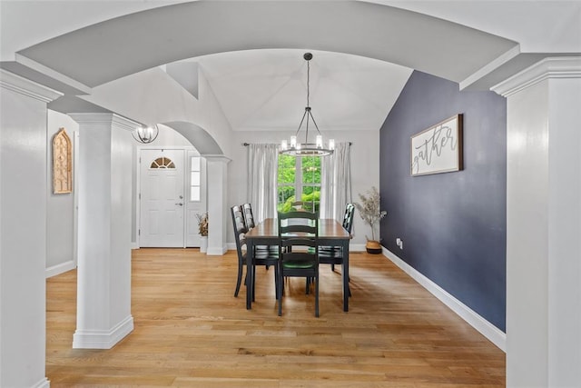 dining room featuring a chandelier, baseboards, vaulted ceiling, and light wood-style floors