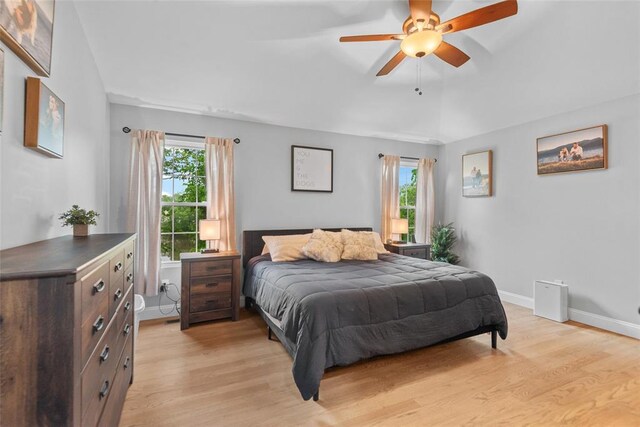 bedroom with light wood finished floors, baseboards, and a ceiling fan