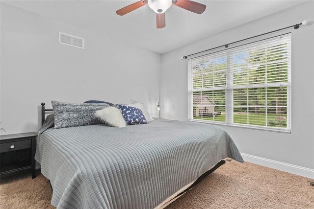 carpeted bedroom with baseboards and a ceiling fan