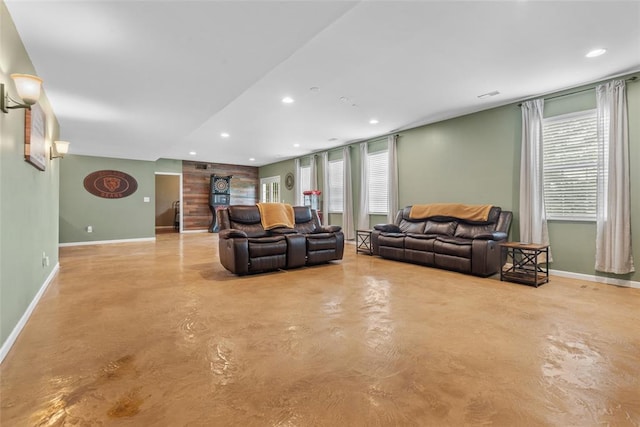 living area featuring concrete flooring, baseboards, and recessed lighting
