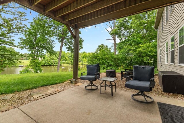 view of patio featuring a water view and view of wooded area
