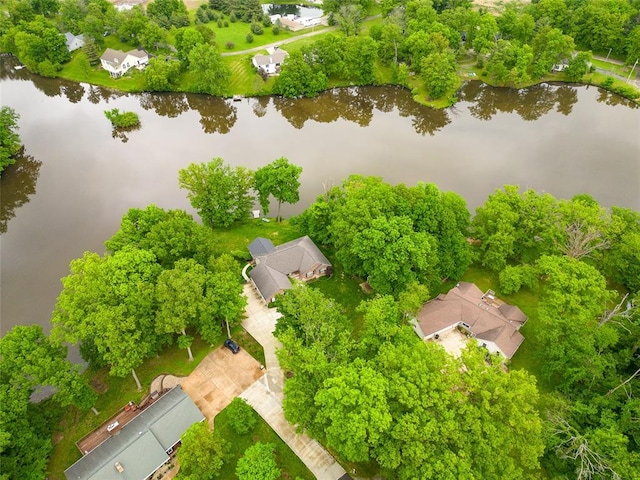 aerial view of residential area with a nearby body of water and a tree filled landscape