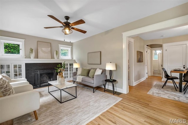 7439 Wellington Ave, University City, MO 63130 - living room with healthy amount of natural light, light wood-style floors, a ceiling fan, and arched walkways