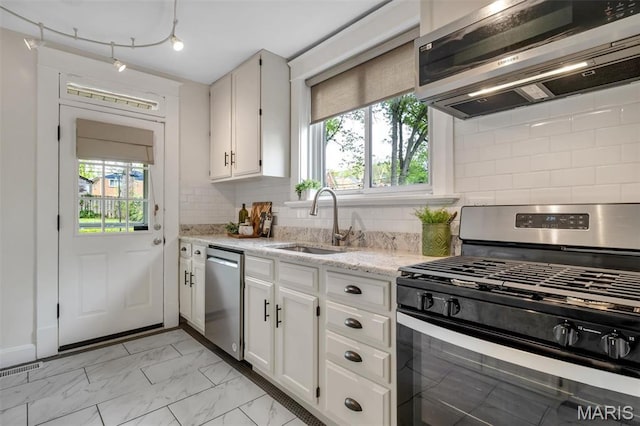 7439 Wellington Ave, University City, MO 63130 - kitchen featuring appliances with stainless steel finishes, plenty of natural light, and white cabinetry